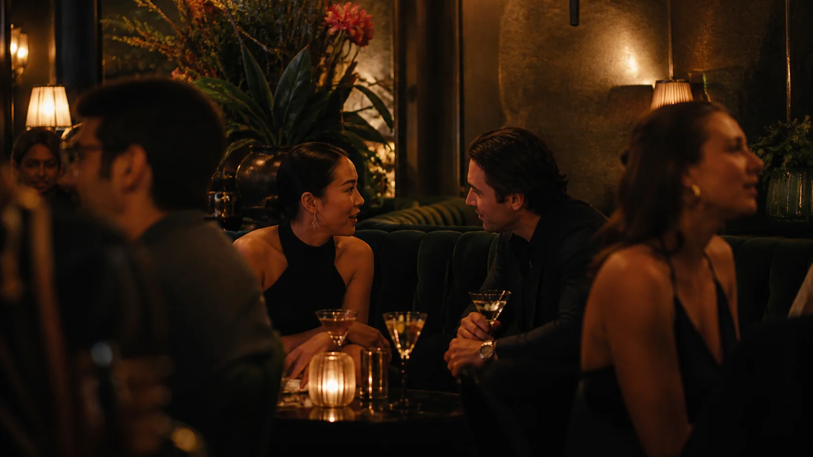 Personas conversando y compartiendo cócteles en un bar de ambiente íntimo